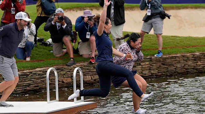 Lilia Vu (right) jumps into a pond after winning the 2023 Chevron Championship.